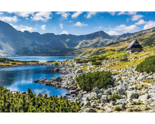 Een serene weergave van een bergmeer, met bergen die reflecteren in het kalme water, op dit fotobehang.