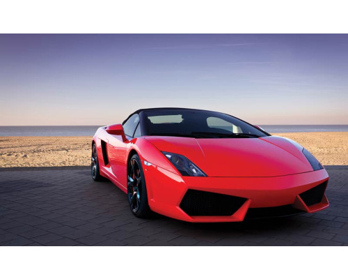 Fotobehang van een rode Lamborghini aan zee, sportauto in een exotisch landschap.