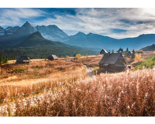 Fotobehang van majestueuze bergen die oprijzen onder een stralende hemel, met een weids uitzicht over de natuur.