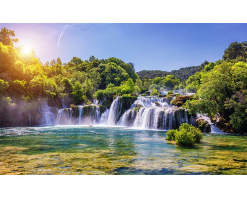 Fotobehang van de Skradinski Buk-waterval in Krka National Park, waar het water door een weelderig groen bos stroomt.