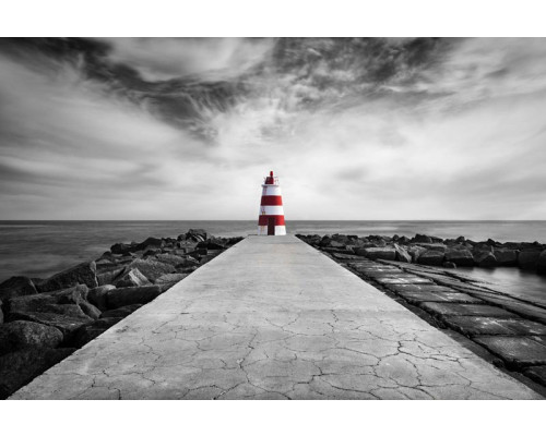 Fotobehang van een vuurtoren op het strand van Praia da Rocha, Algarve, met de zee die tegen de kustlijn klotst.
