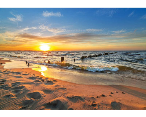 Fotobehang van een zonsondergang boven de zee, met een helder verlichte hemel en een serene strandomgeving.