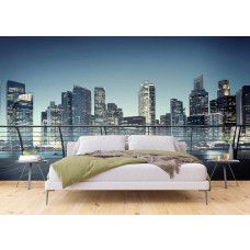 Een slaapkamer met een fotobehang van het uitzicht in 3d op wolkenkrabbers in een verlichte stad.