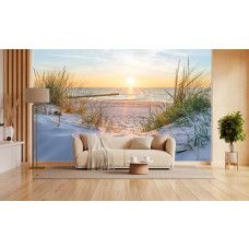 Fotobehang van een zonsondergang boven een strand, zee en duinen, met warme en rustgevende kleuren in een moderne woonkamer.