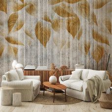 Een fotobehang van gouden bladeren op ruw beton in een huiskamer.