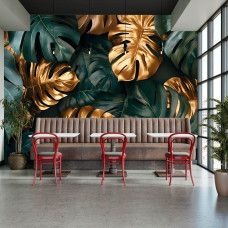 Fotobehang met monstera bladeren en gouden details in een restaurant met chique ambiance.