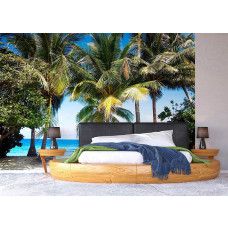 Een fotobehang van palmbomen langs de zee in een slaapkamer.
