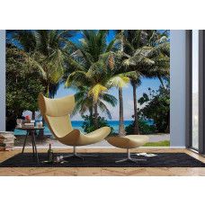 Een fotobehang van palmbomen langs de zee in een woonkamer.