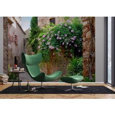 Een fotobehang van een patio tuin in Peratallada in een woonkamer met vliesbehang.