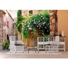 Een fotobehang van een patio tuin in Peratallada in een woonkamer.