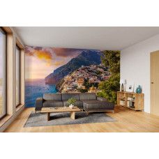 Fotobehang Positano bij zonsondergang in de woonkamer met uitzicht over zee en bergdorp.
