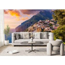 Een woonkamer met een fotobehang met daarop Positano bij zonsondergang.