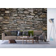 Een fotobehang van een stenen muur met steenstrips, ideaal voor het creėren van een warme, rustieke sfeer in een huiskamer.