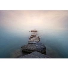 Een fotobehang van een stenen pad in het water.