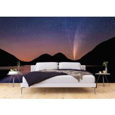 Een fotobehang van een sterrenhemel boven bergen en een meer in een slaapkamer.