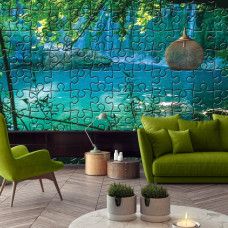 Een fotobehang met een turquoise meer en waterval in de jungle, ideaal voor een woonkamer.