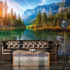 Fotobehang van een zonsondergang bij Hintersee, met een schilderachtig bergmeer dat de warme avondkleuren weerspiegelt, omringd door prachtige hoge bergen, in een woonkamer.