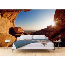 Een 3D fotobehang van een zonsondergang vanuit een grot in een slaapkamer.