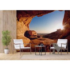 Een 3D fotobehang van een zonsondergang vanuit een grot in een woonkamer.