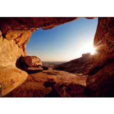 Een 3D fotobehang van een zonsondergang vanuit een grot.
