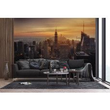 Een huiskamer met een fotobehang met een magische zonsondergang boven de wolkenkrabbers van de New York skyline.