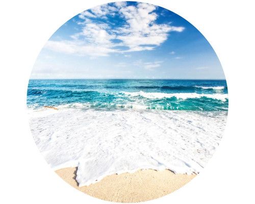 Zonsondergang op een tropisch strand met helderblauw water en witte wolken, afgebeeld op een behangcirkel.