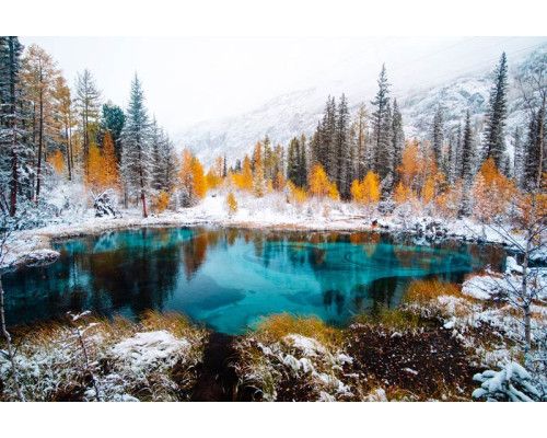 Fotobehang van een geisermeer in Siberië, Rusland, omgeven door bossen en bergen, met een mystieke uitstraling.