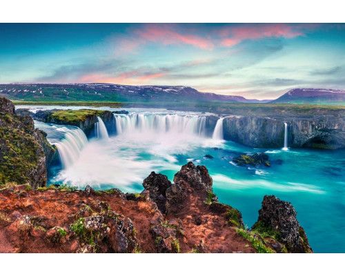 Fotobehang van de Godafoss waterval in IJsland met kolkend water en omringende rotsformaties.