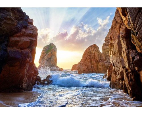 Fotobehang van golven die tussen de rotsen doorbeuken, met de bergen op de achtergrond in een weelderig natuurlandschap.