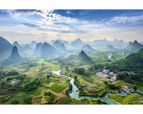 Fotobehang van het karstgebergte in het dorpje Yangshuo, China, met bergen die oprijzen boven een pittoresk landschap.
