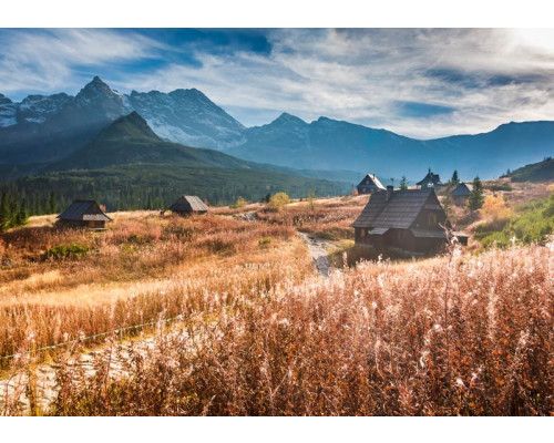 Fotobehang van majestueuze bergen die oprijzen onder een stralende hemel, met een weids uitzicht over de natuur.