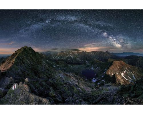 De melkweg die boven bergen en sterren schijnt, prachtig afgebeeld op dit natuurgetrouwe fotobehang.