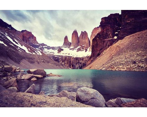 Fotobehang van het Nationaal Park Torres del Paine in Chili, met bergen die hoog oprijzen boven een ruig natuurlandschap.