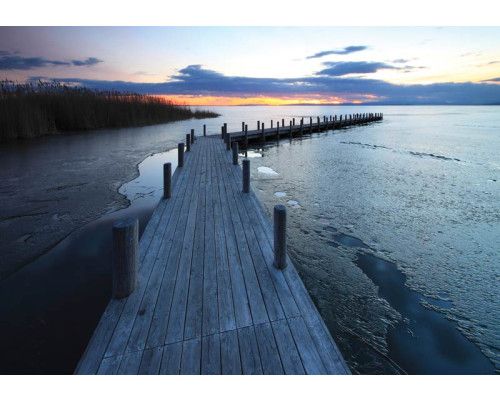 Fotobehang van een pier aan een meer met water en hout, serene landschapsfoto.