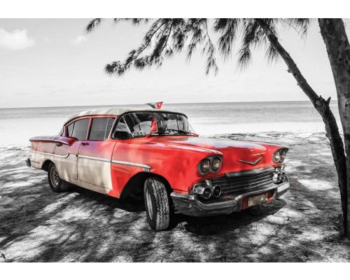 Retro auto in Cuba, geparkeerd langs een strand met palmbomen en helderblauwe zee, fotobehang voor een nostalgische sfeer.