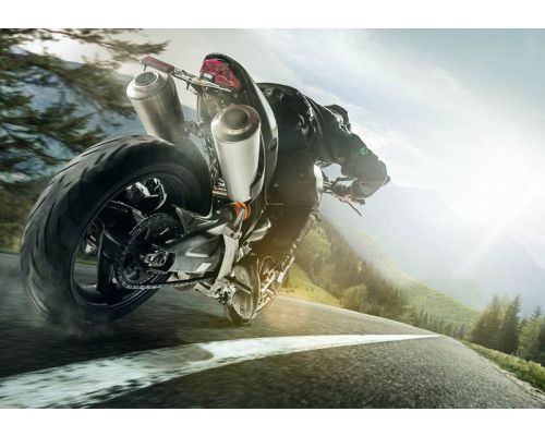 Fotobehang snelle motor in de bergen met een indrukwekkend uitzicht op een lange weg en prachtige bergen.