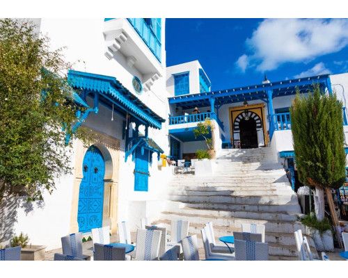Fotobehang van een straat in Tunesië, met blauwe huizen en een mediterrane sfeer.