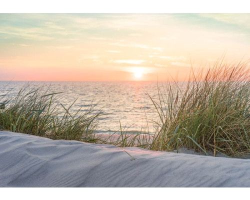 Fotobehang van een strand en duinen bij zonsondergang, warme kleuren.