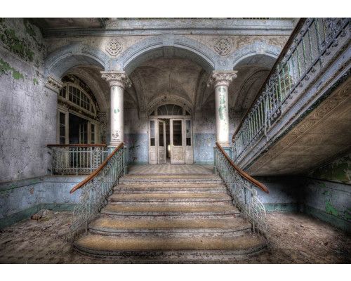 Verlaten gebouw fotobehang met een industriële trap, dat zorgt voor een rauwe en verweerde sfeer in de ruimte.