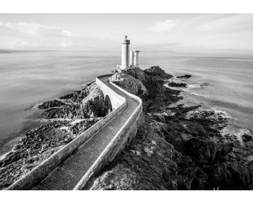 Fotobehang met een vuurtoren aan zee, schilderachtig landschapsbeeld.