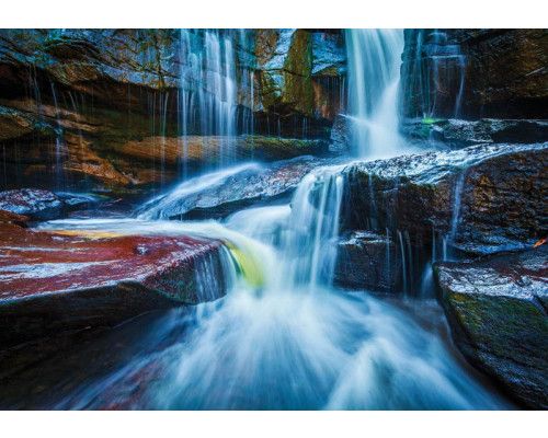 Fotobehang van een waterval tussen rotsen, natuurgetrouw landschap.
