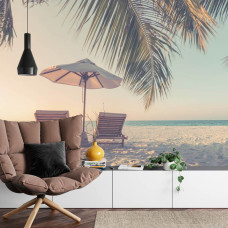 Een levendig fotobehang van een tropisch strand met ligbedden en palmbomen, perfect voor een woonkamer.