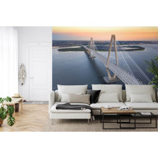 Een fotobehang met een uitzicht op de Arthur Ravenel Jr. Bridge in een rustige setting, afgebeeld in een woonkamer.