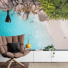Een rustgevend fotobehang met een tropisch uitzicht op zee en palmbomen, perfect voor een huiskamer.
