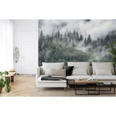 Een fotobehang met een berglandschap met mist en hoge bomen in een woonkamer.