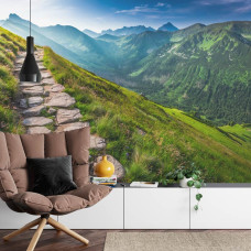 Een fotobehang met een schilderachtig bergpad langs imposante bergen, ideaal voor een huiskamer.