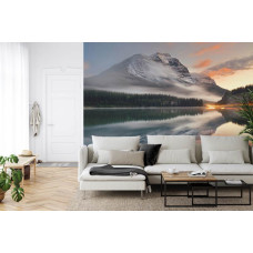 Een fotobehang met een serene scčne van een meer met omliggende bergen en bossen in een huiskamer.