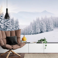 Een fotobehang met een sfeervol wintertafereel van een bos en bergen bedekt met een dikke laag sneeuw, geschikt voor een huiskamer.