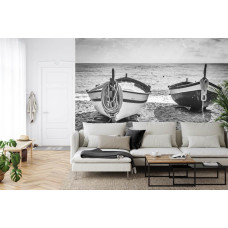 Een fotobehang met kleine bootjes rustig dobberend aan de rand van een strand, ideaal voor een woonkamer.