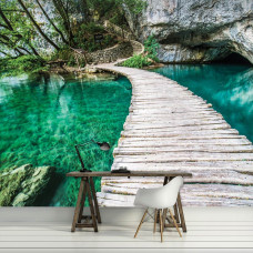Een fotobehang met een houten brug over een turquoise vijver, ideaal voor een serene woonkamer.